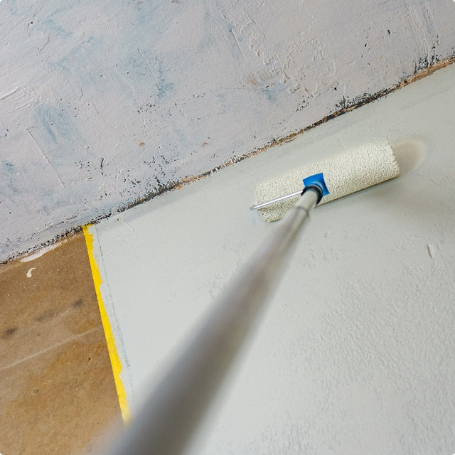 Roll out the floor coating along the taped edge